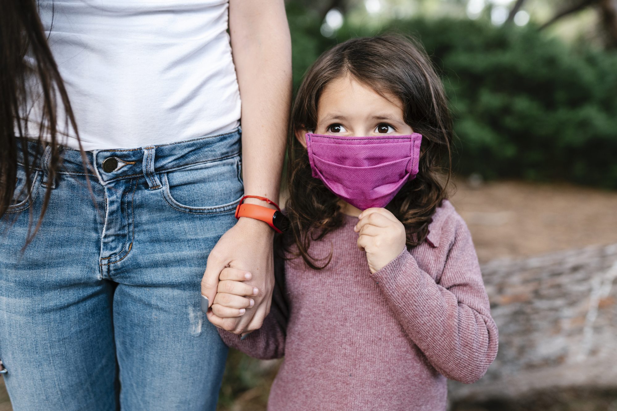 An image of a mom holding her daughter's hand.