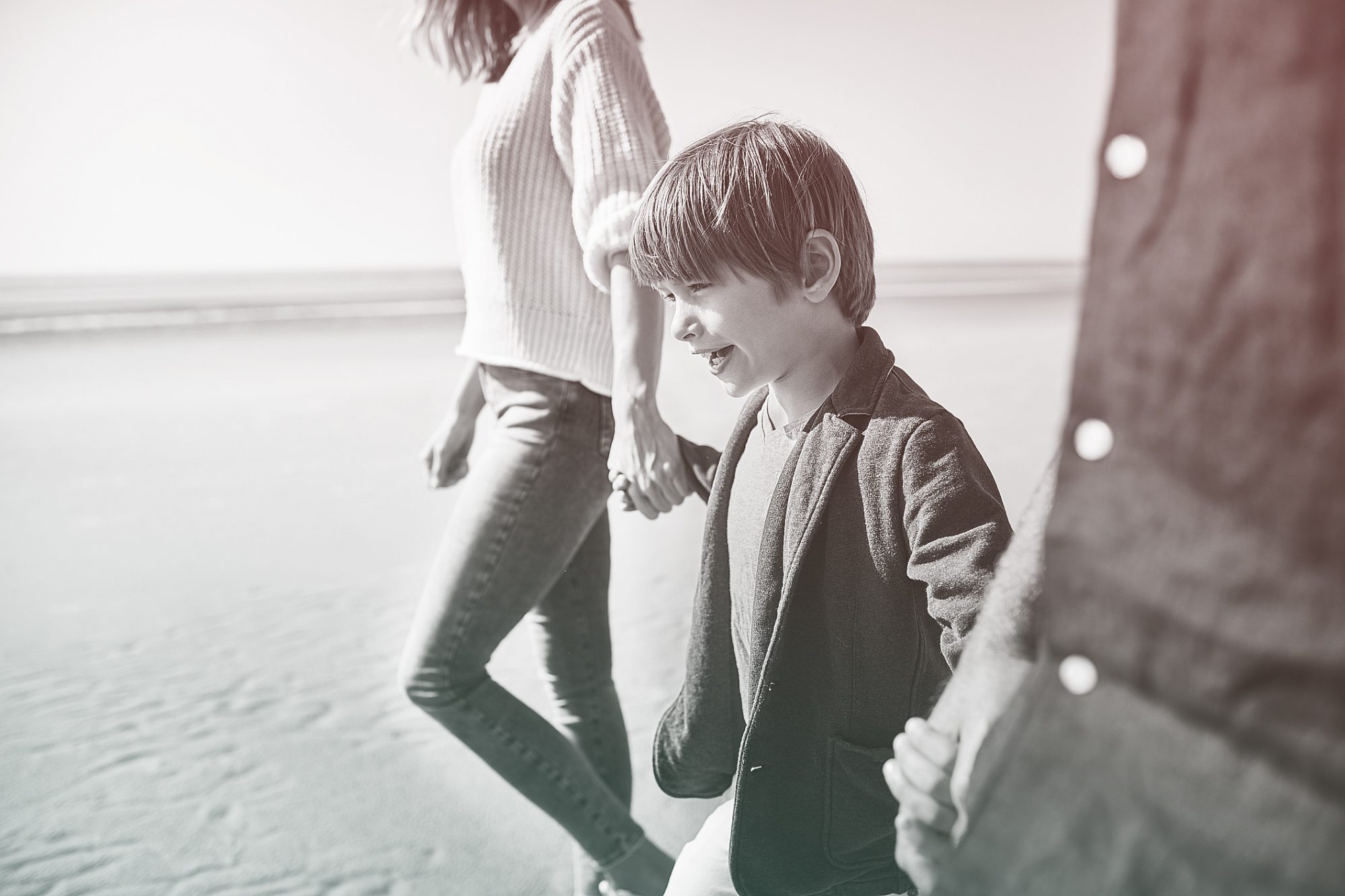 Family walking hand in hand on the beach