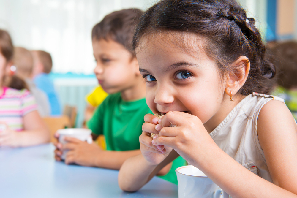 little girl eating a snack at daycare