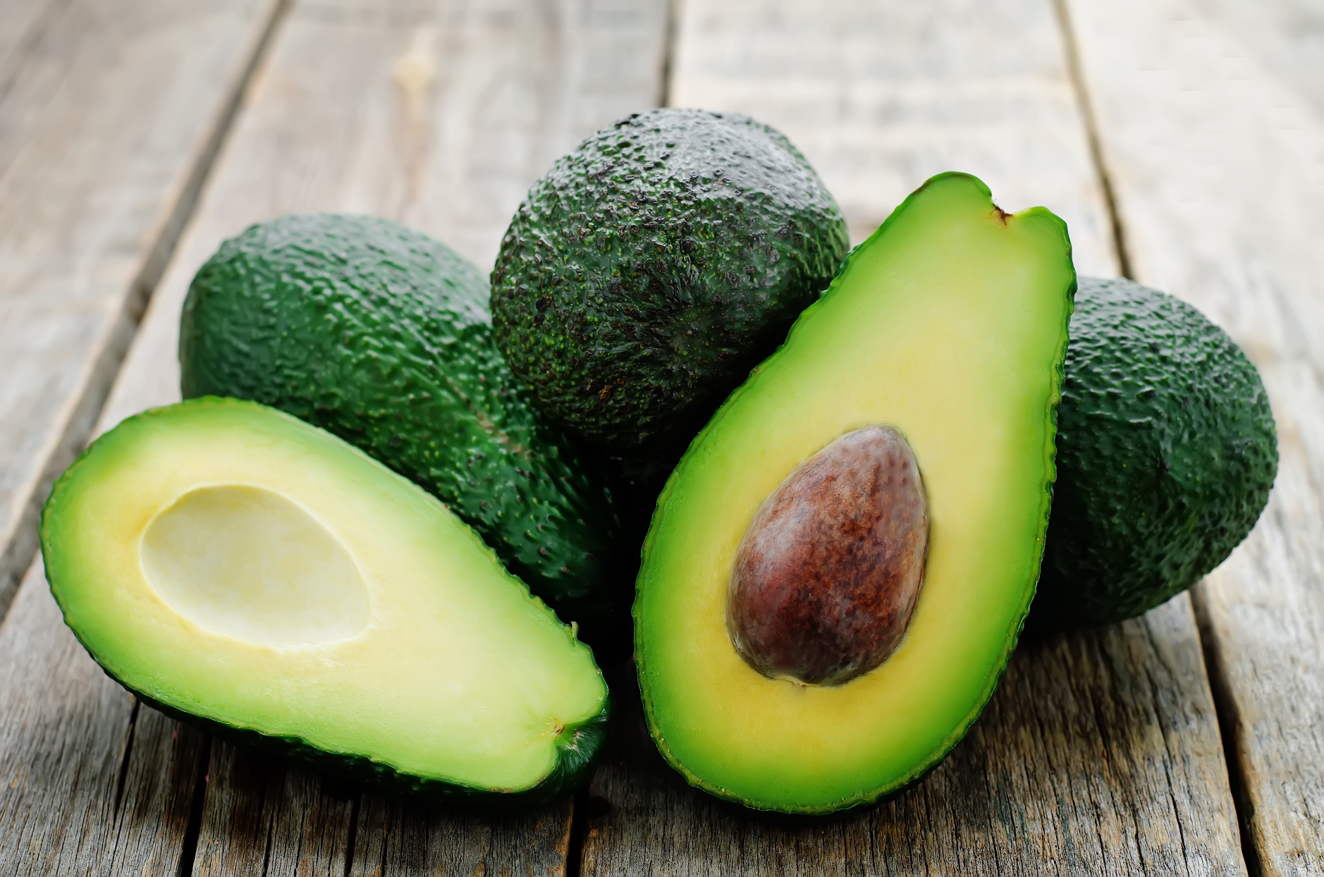 Avocados Cut Open on Wood Table