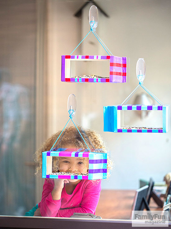 Girl looking out window at bird feeders