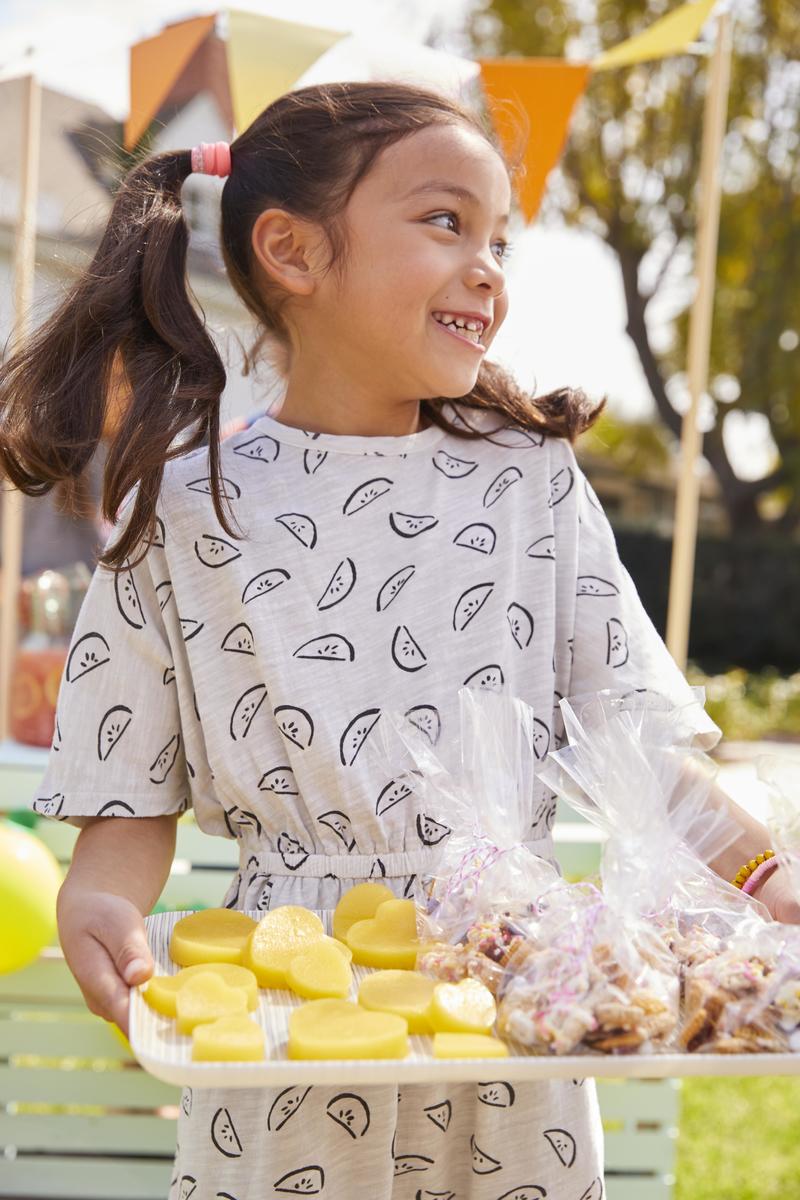 Young Girl Holding Tray of Treats Lemonade Stand