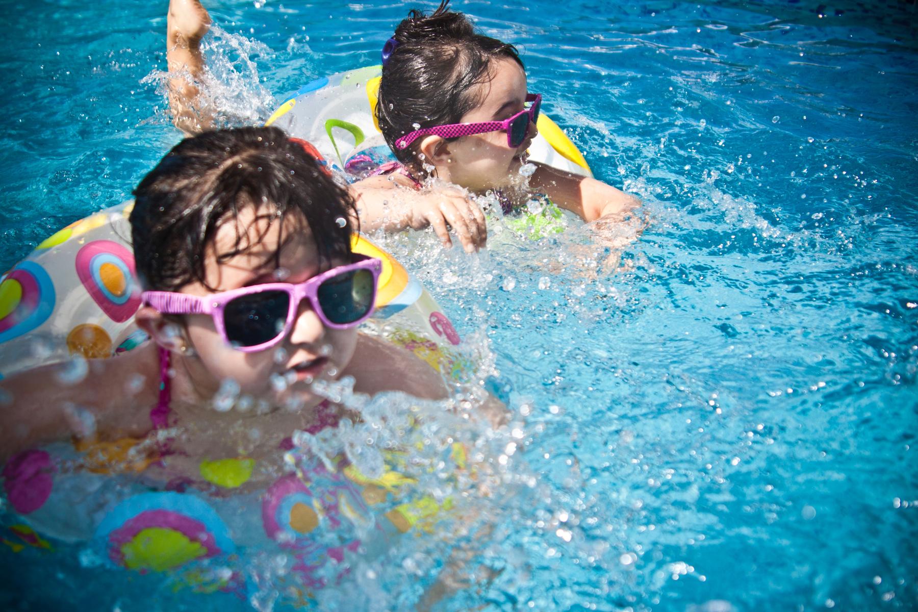 Two Girls in Floaties Playing in Pool