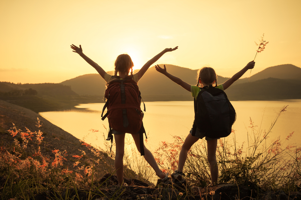 girls hiking at sunset