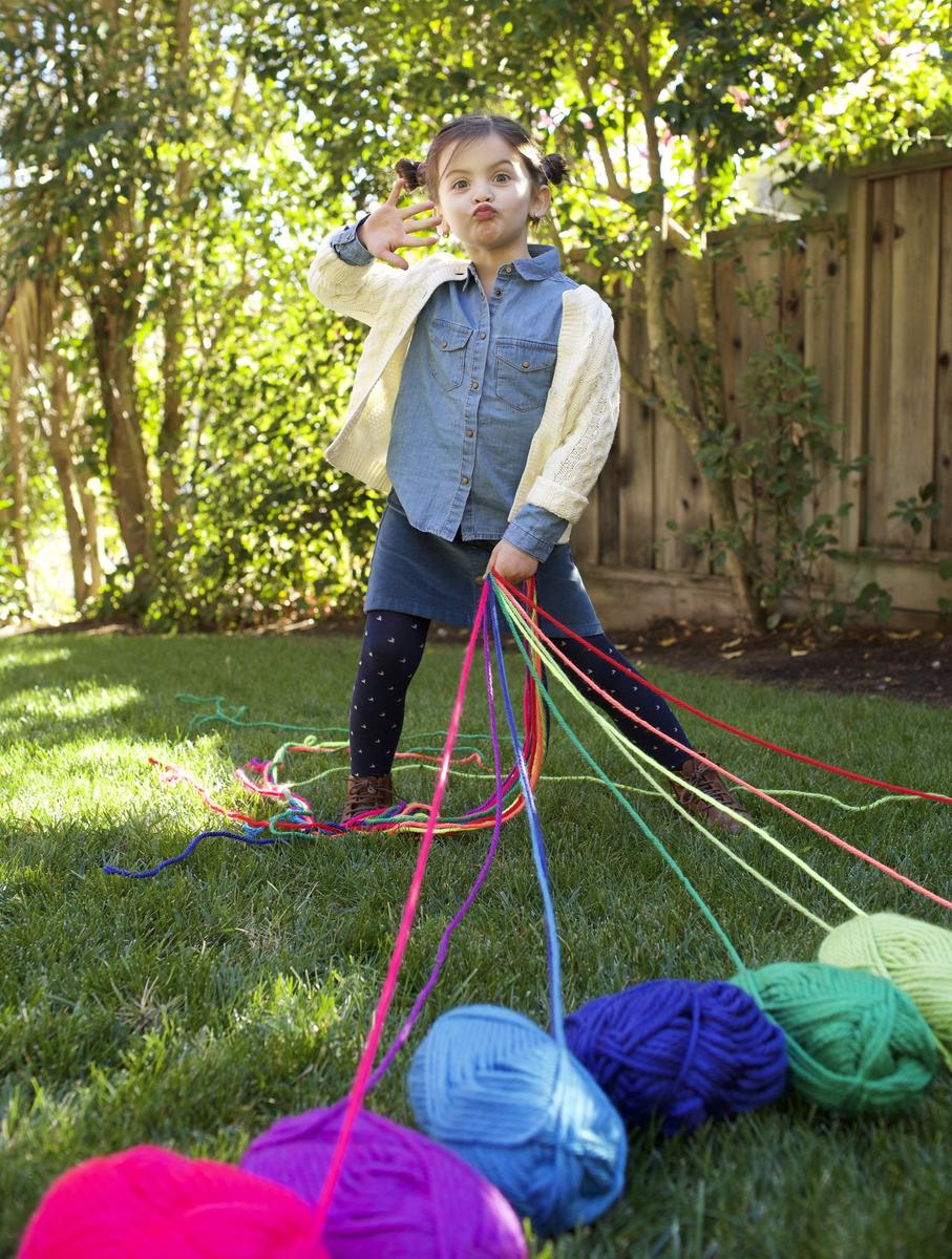 girl holding colorful string making funny face