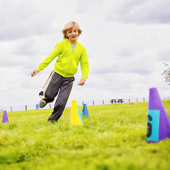 boy running through cones