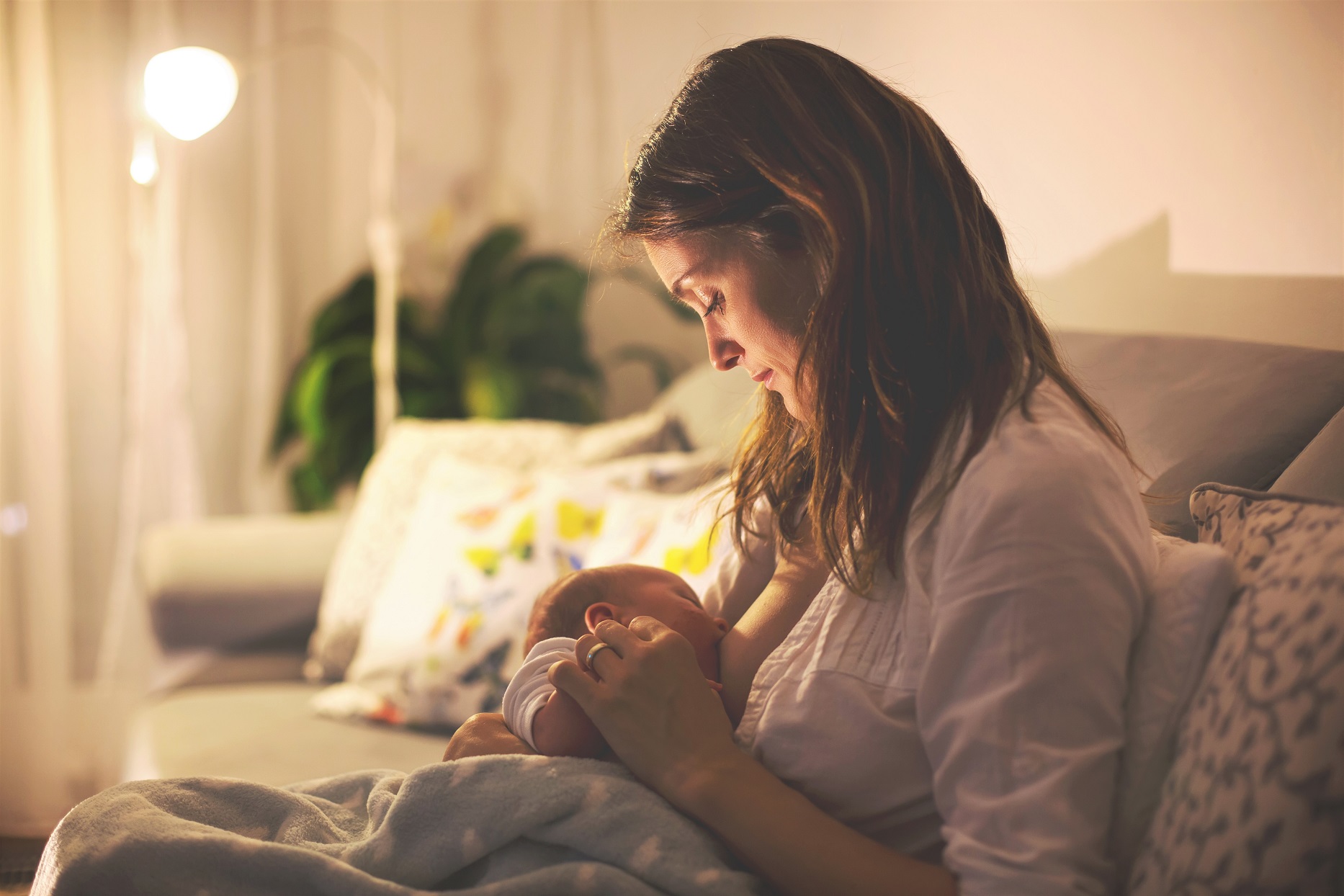 Breastfeeding Mother Looking At Baby on Couch