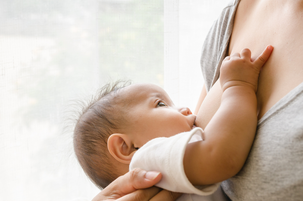 baby looking at mom while breastfeeding