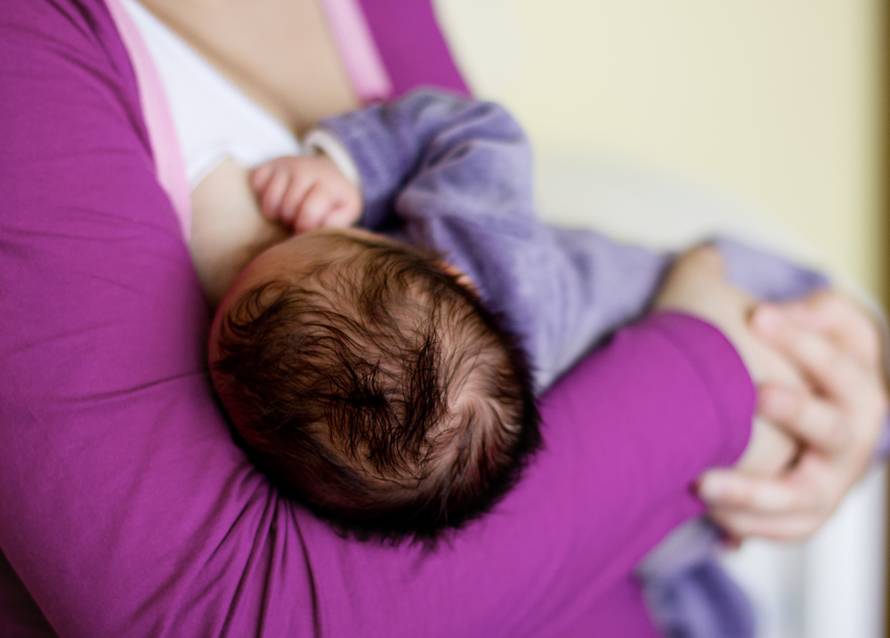 Mom breastfeeding baby uncovered